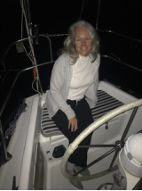 Me sitting at the helm enjoying the evening air and boat life.